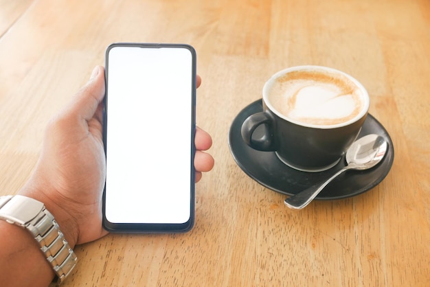 Tenere una cpu di caffè e utilizzare uno smartphone con schermo verde