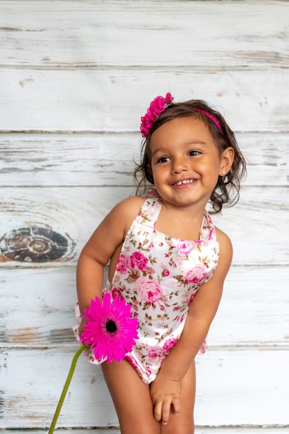 Tenero bambino sorridente, con un fiore in mano