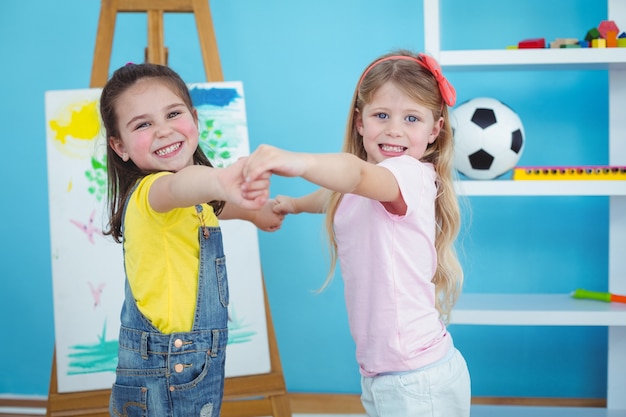 Tenersi per mano di bambini felici