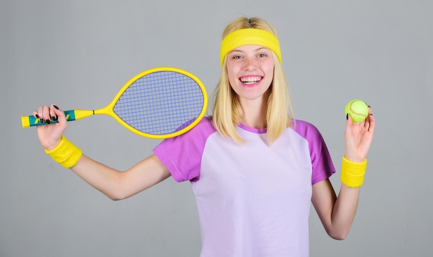 Tennis sport e intrattenimento Tennis club concept Ragazza adorabile bionda gioca a tennis Sport per il mantenimento della salute L'atleta tiene in mano la racchetta da tennis su sfondo grigio Tempo libero attivo e hobby