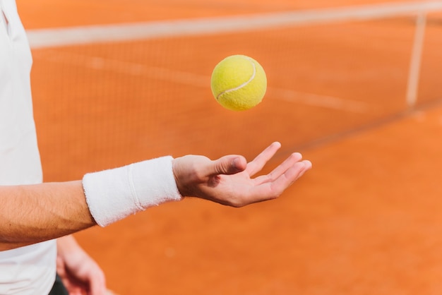 Tennista che lancia pallina da tennis