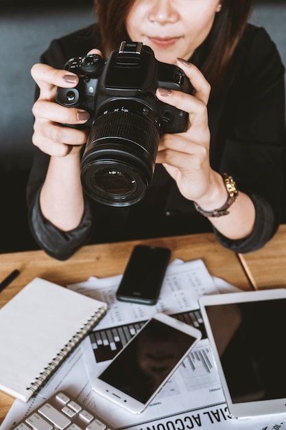 Tenuta della donna del primo piano con la macchina fotografica di fotografia