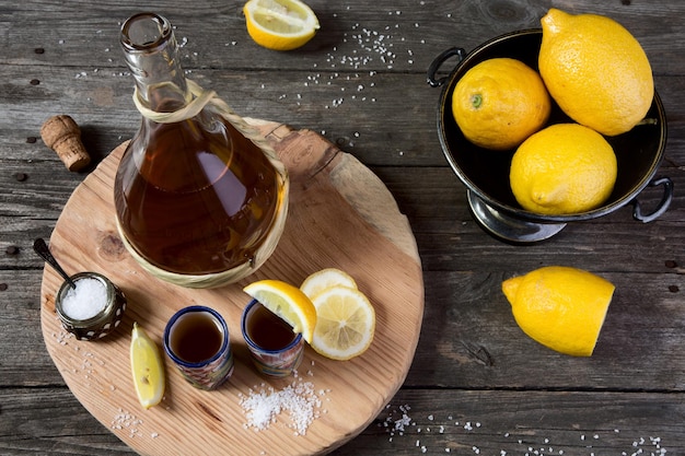 Tequila con limone e sale su un tavolo di legno