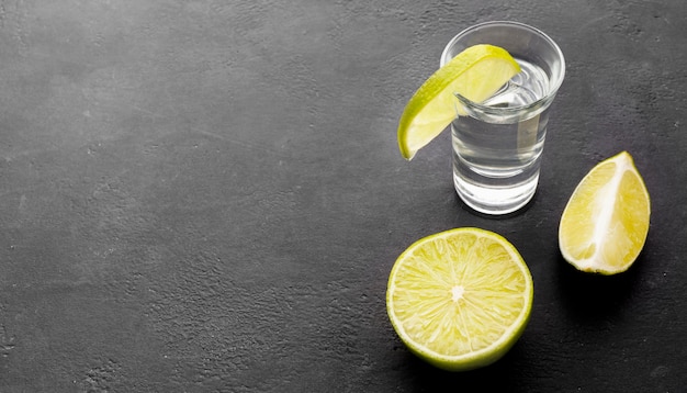 Tequila d'argento ad alto angolo girato con fette di lime