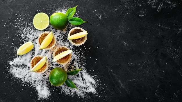 Tequila d'oro con lime e sale su sfondo di pietra nera Vista dall'alto Spazio libero per il testo