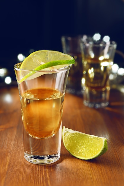 Tequila dell'oro sparata con calce sulla barra di legno