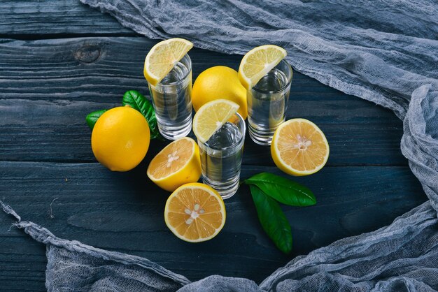 Tequila limone fresco e succo di limone su uno sfondo di legno Vista dall'alto Spazio libero per il testo