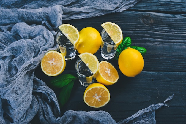 Tequila limone fresco e succo di limone su uno sfondo di legno Vista dall'alto Spazio libero per il testo