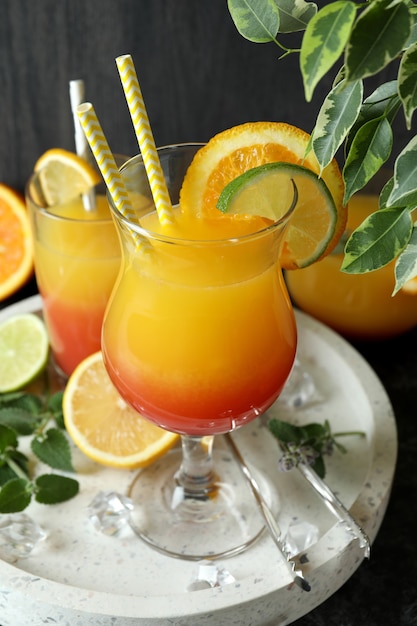 Tequila sunrise cocktail e ingredienti su sfondo scuro