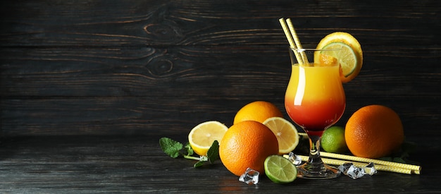 Tequila sunrise cocktail e ingredienti sul tavolo di legno