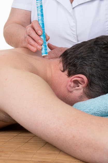 Terapeuta di agopuntura che usa la moxibustione per riscaldare un'area sul collo di un paziente