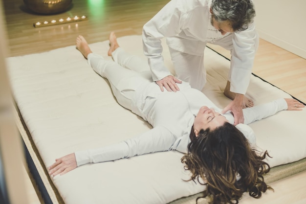 Terapeuta uomo che fa un massaggio shiatsu a una donna trattamento di terapia olistica con manipolazione