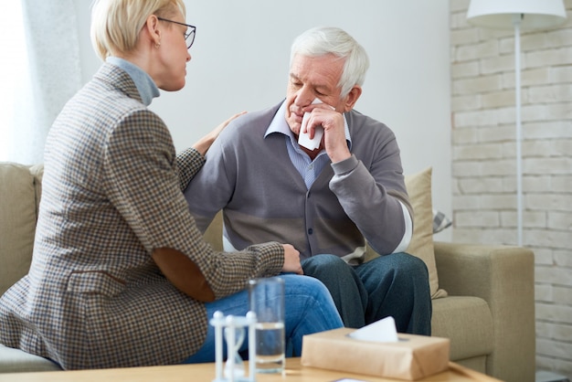 Terapista che conforta paziente senior