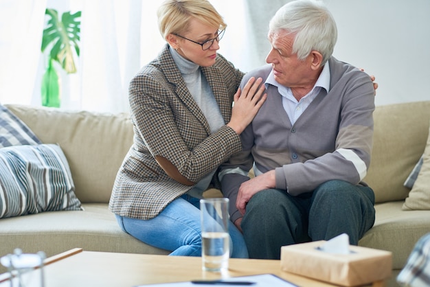 Terapista che conforta paziente senior