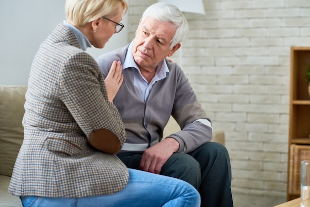 Terapista che conforta paziente senior