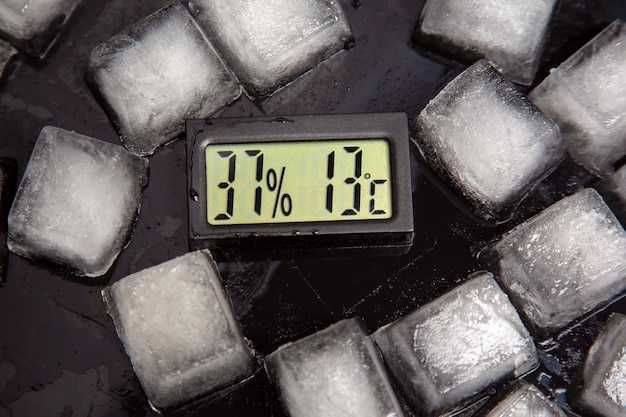 termometro digitale per misurare la temperatura e l'umidità dell'aria sullo sfondo del ghiaccio ghiacciato