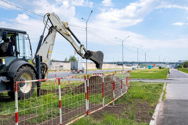 Terna durante i lavori di scavo all'aperto in un cantiere edile Il terreno è recintato con recinzioni mobili temporanee