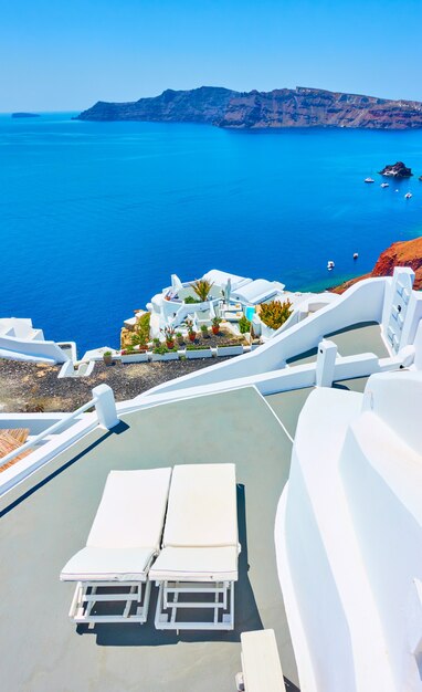 Terrazza con due chaise longue in riva al mare a Santorini, Grecia. paesaggio greco