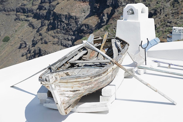 Terrazza con una vecchia barca di legno sull'isola di Santorini in Grecia