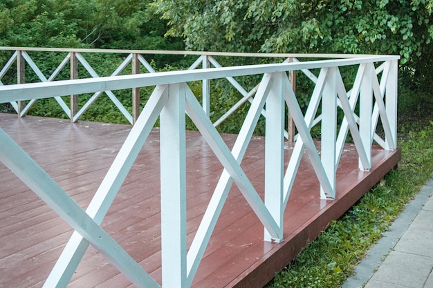 Terrazza estiva all'aperto con pavimento in legno marrone e ringhiere a forma di grata