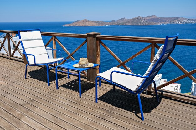 Terrazza in legno della villa o dell'hotel con due sedie bianche e un tavolo