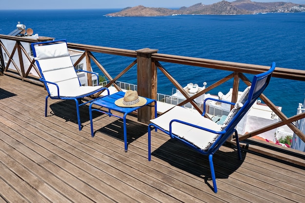 Terrazza in legno della villa o dell'hotel con due sedie bianche e un tavolo