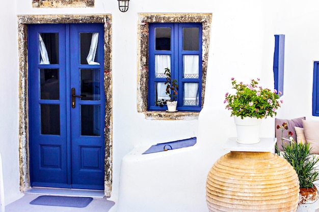 Terrazza in stile greco con vasi di fiori decorativi e mobili da giardino a Santorini, Grecia