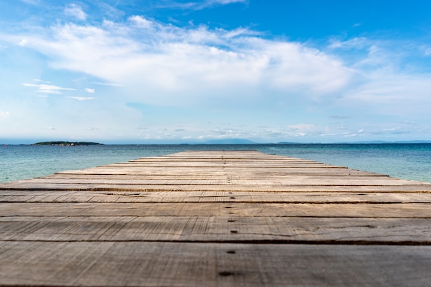 Terrazza vintage in legno sulla spiaggia con mare blu, oceano, sfondo del cielo