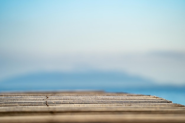 Terrazzo d'annata di legno sulla spiaggia con il fondo blu del cielo dell'oceano del mare