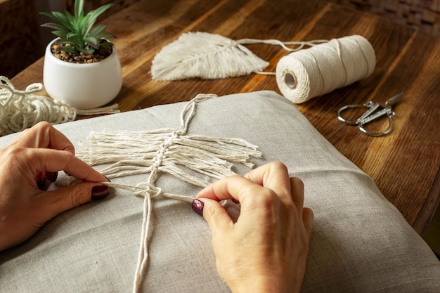 Tessitura di macramè a casa. La mano della donna quando fa il macramè.