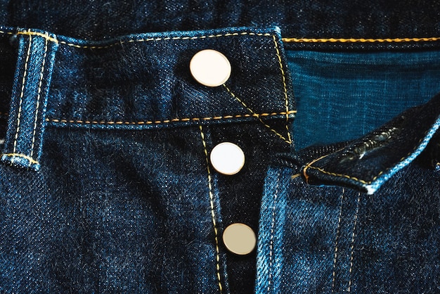 Tessuto denim di pantaloni jeans con cucitura e filo e bottoni in ottone per il design