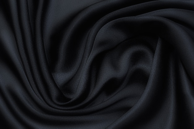 Tessuto di seta in nero in layout artistico. Trama, sfondo, motivo.