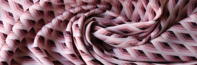 Tessuto rosa e bianco roteato con ornamento geometrico come sfondo primo piano di rosa ondulato