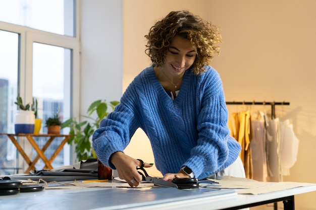 Tessuto tagliato da ragazza di design per la nuova collezione di moda sartoriale su misura con forbici e motivo