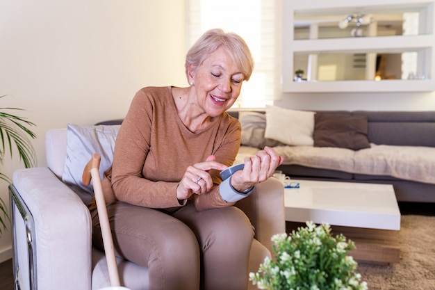 Test della pressione sanguigna a casa. Controllo del livello di pressione sanguigna a casa. Donna senior che controlla i livelli di pressione sanguigna a casa