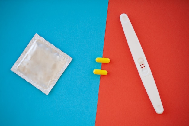 Test di gravidanza. Il risultato è positivo con due strisce e preservativo con contraccettivo, pillola anticoncezionale, sesso sicuro, concetto sanitario