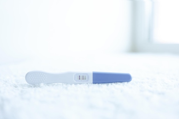 Test di gravidanza positivo su sfondo bianco