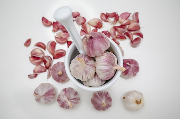 testa d'aglio sul tavolo con macina spezie