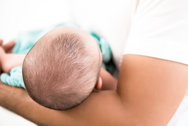 Testa del neonato nel braccio del padre