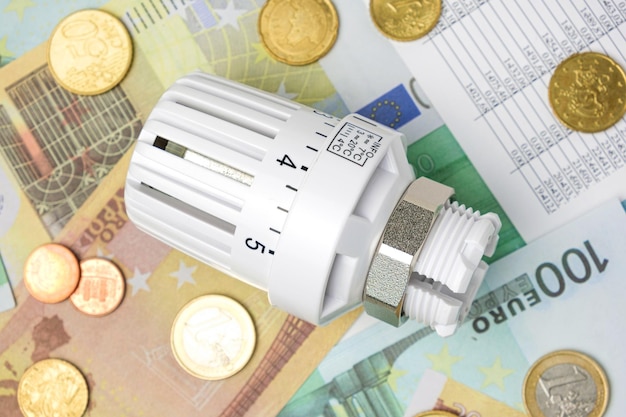 Testa della valvola termostatica sulle banconote in euro Contesto Aumento del consumo Costo dell'elettricità e concetto di energia costosa Aumento dei prezzi Crisi del riscaldamento Risparmio della bolletta Conservazione Inflazione