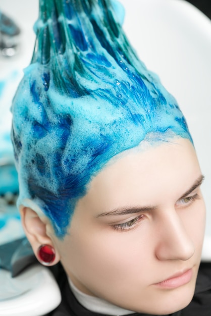 Testa di donna con i capelli blu mentre lava la testa in un salone di bellezza professionale dopo aver tinto i capelli