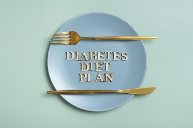 Testo del programma dietetico per il diabete su piatto su sfondo colorato con posate piatte vista dall'alto