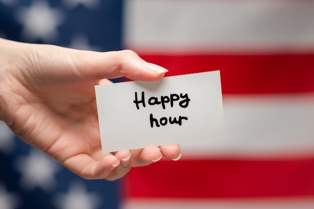 Testo di happy hour su una carta. Sfondo bandiera americana.