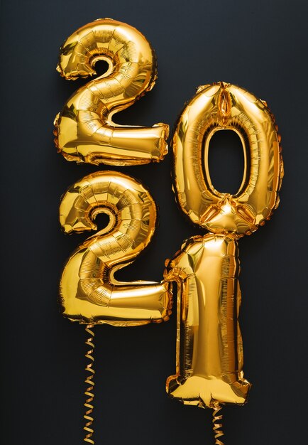 Testo di palloncini d'aria oro felice anno nuovo 2021 su formato verticale nero.