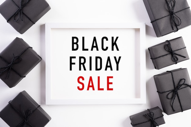 Testo di vendita di Black Friday sulla cornice bianca con il contenitore di regalo nero