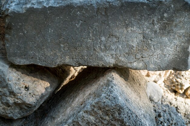 Testo greco scolpito su antiche pietre delle rovine di Phaselis antica città greca sulla costa di Antalia in Turchia