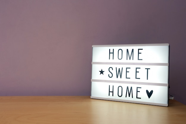 Testo 'Home sweet home' in lighbox su mensola in legno, moderna decorazione retrò