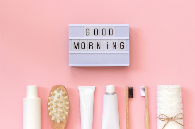 Testo light box Buongiorno e set di prodotti cosmetici e strumenti per la doccia o il bagno su sfondo rosa