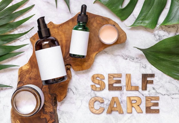 Testo Self Care vicino a flaconi cosmetici e foglie di monstera mockup vista dall'alto