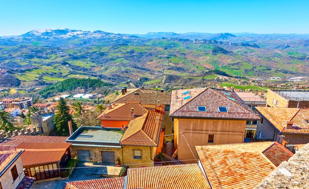 Tetti di tegole a San Marino e paesaggio con montagne sullo sfondo